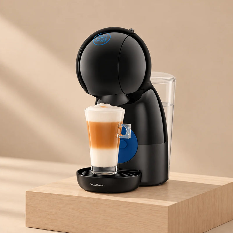 Cafetera Nescafé® Dolce Gusto® Piccolo XS negra con un latte macchiato, sobre un pedestal de madera