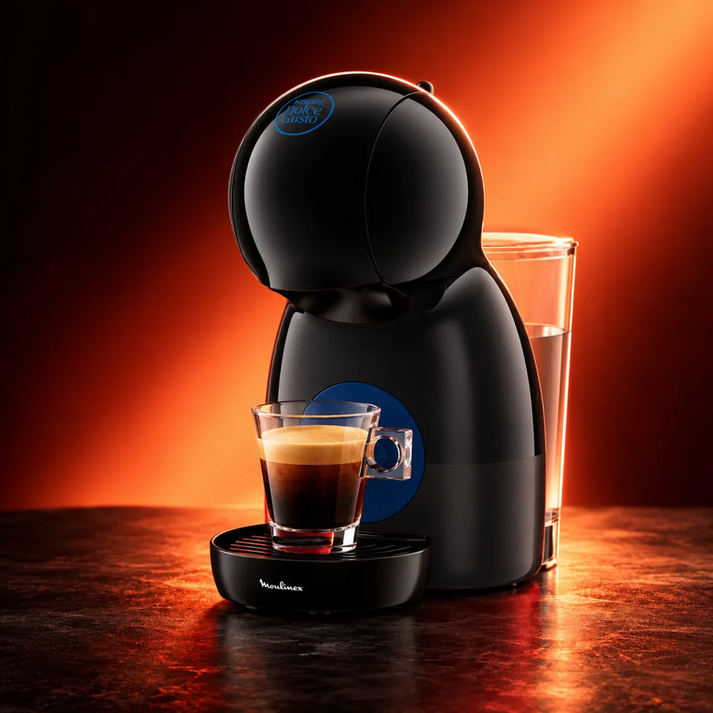Cafetera Nescafé® Dolce Gusto® Piccolo XS negra con un espresso, con luz roja de fondo