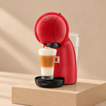 Cafetera Nescafé® Dolce Gusto® Piccolo XS roja con un latte macchiato, sobre un pedestal de madera