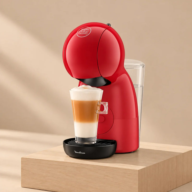 Cafetera Nescafé® Dolce Gusto® Piccolo XS roja con un latte macchiato, sobre un pedestal de madera
